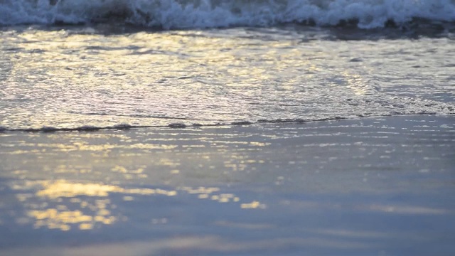 夏天日落时海滩上的海浪。视频素材