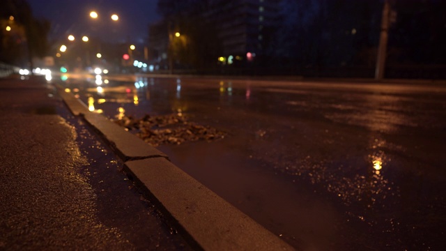 秋雨交加的夜晚，街灯映照在水坑里视频素材