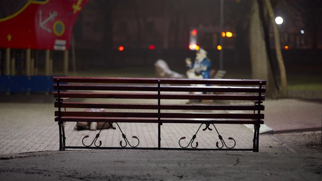 秋天的夜晚，城市公园里空荡荡的儿童操场上的长凳。视频素材