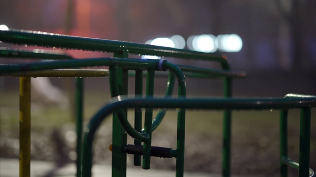 秋天的夜晚，在城市公园的空旷儿童游乐场，潮湿的旋转木马在旋转。视频素材