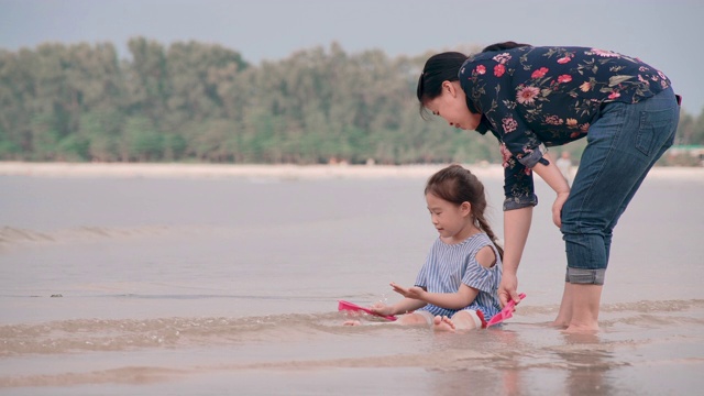 妈妈和女儿在海滩上玩耍视频素材