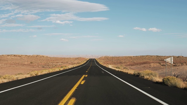 在黑色沥青和黄色线的道路上驾驶在美国沙漠从汽车视频素材