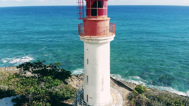 夏天蓝色海面附近的白色灯塔。晴天灯塔鸟瞰图。视频素材