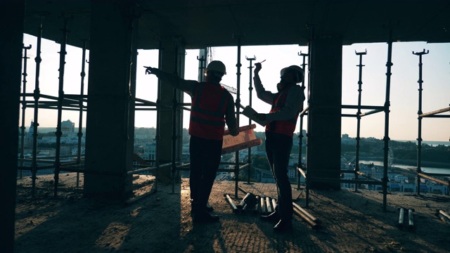 专业的建筑工程师，建筑建筑师一起在建筑工地工作。视频素材