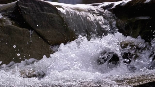 有雪的山溪和石滩。水流湍急。冬天的瀑布。慢动作视频素材