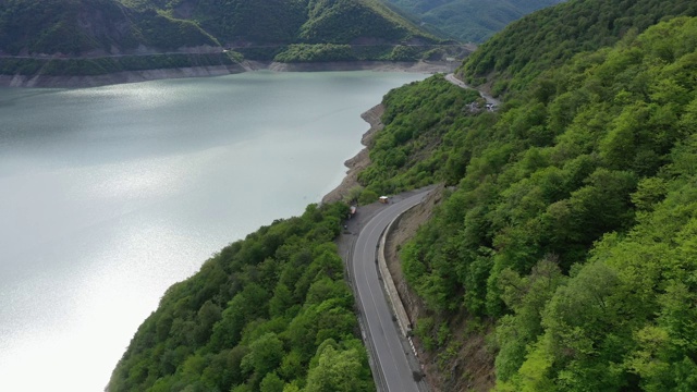 公路上有一座风景如画的山坡。山附近的湖。视频素材