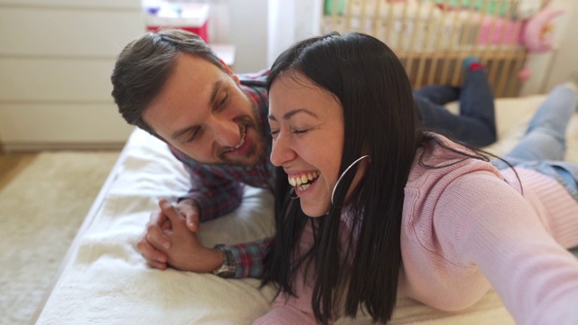一对年轻幸福的情侣在卧室里自拍视频素材