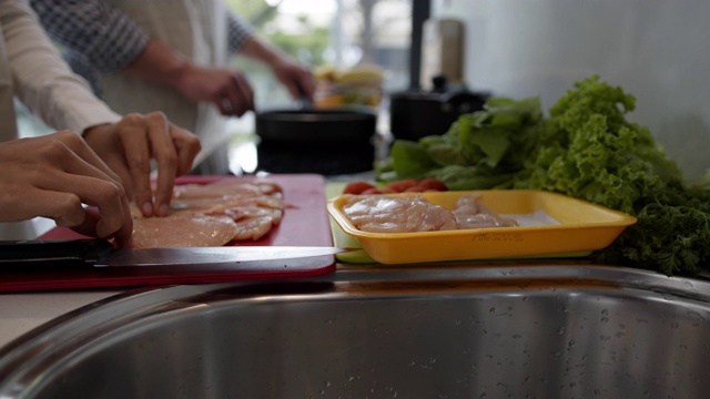 这是一对面目全非的夫妇在家里一起做饭的特写视频素材