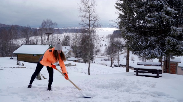 女人用铲子清扫雪。冬天铲。暴风雪后清除积雪。视频素材