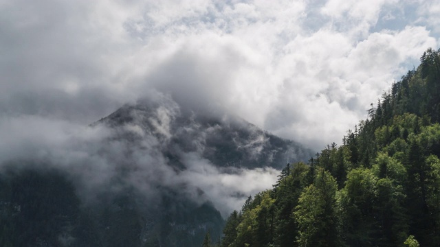 低角度视角:山覆盖云周围的雾在下雨的日子在夏季哈尔斯塔特视频素材