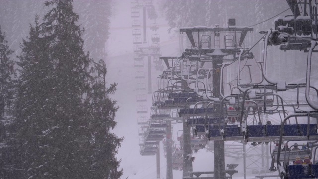 滑雪胜地的滑雪缆车，慢动作。滑雪者爬上滑雪椅电梯去滑雪斜坡视频素材