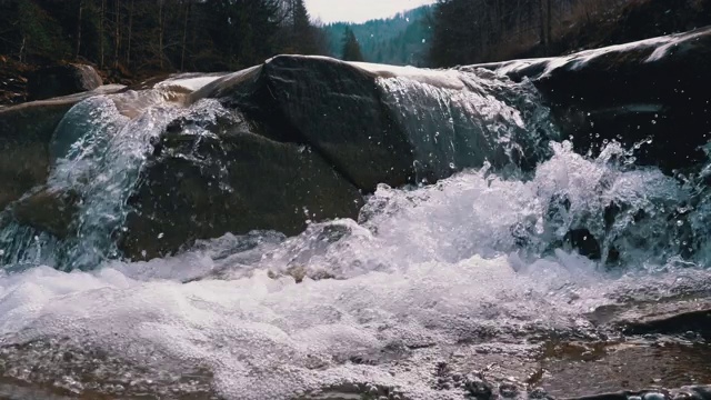 有雪的山溪和石滩。水流湍急。冬天的瀑布。慢动作视频素材