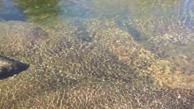 清澈的河水，底部有小波浪和岩石视频素材