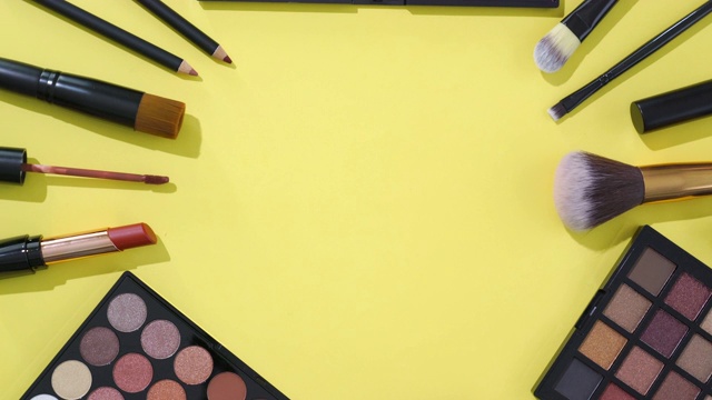 在黄色背景上旋转化妆和化妆笔刷集合视频素材
