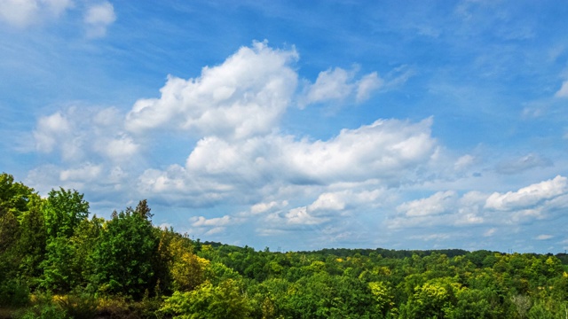 光线穿过云层。美丽的阳光灿烂的cloudscape。美丽的云景，时间流逝的云移动在天空和阳光透过云与射线。4 k循环视频素材