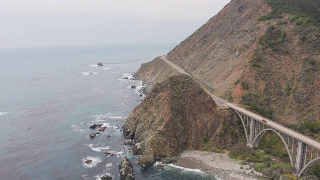 无人机拍摄的一座桥在一个岩石，陡峭的海岸线公路(大苏尔，太平洋海岸公路，加利福尼亚)视频素材