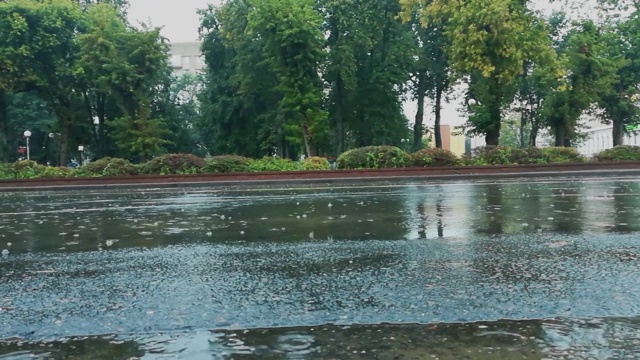 在城市的雨天，汽车在被洪水淹没的道路上行驶，从车轮下喷出水花和喷泉。恶劣和危险的交通条件。手持拍摄视频素材