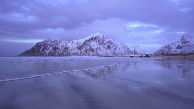 在罗浮敦群岛，北欧郡，挪威，欧洲斯卡格桑登海滩的海景。白雪皑皑的山峦，是冬季自然景观的背景。著名的旅游景点。日落的天空视频素材