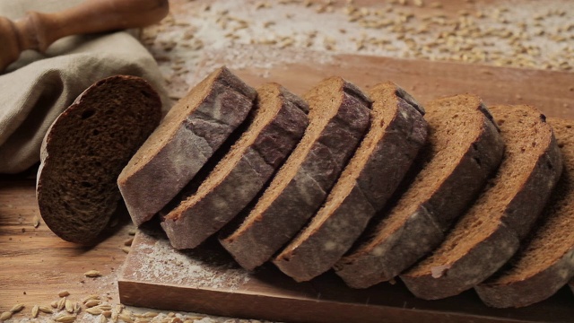 面包掉在桌子上。切片的有机面包掉下来。食品的概念视频素材