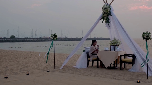 浪漫的海滩晚餐，蜜月晚餐在日落泰国海滩，情人设置视频素材