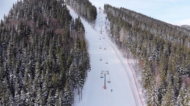 鸟瞰图滑雪者去滑雪胜地滑雪缆车附近的滑雪斜坡。Bukovel视频素材