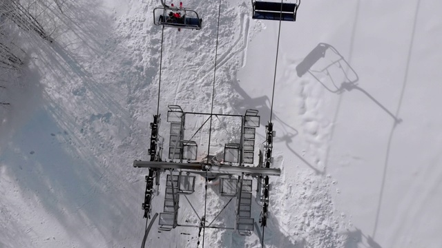 供滑雪坡上的滑雪缆车鸟瞰图。无人机飞过升降椅视频素材