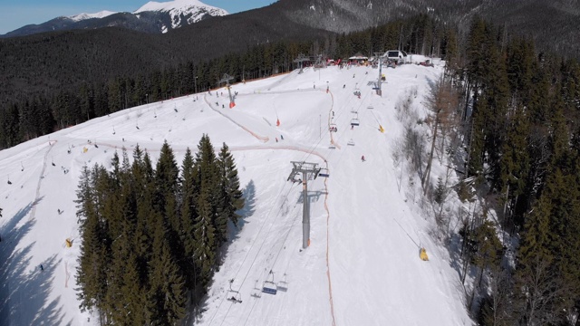 滑雪胜地的空中滑雪场与滑雪者和滑雪缆车。的雪山森林视频素材