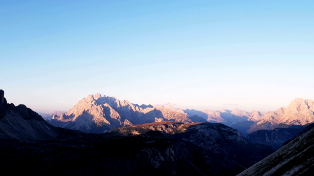 拍摄于意大利阿尔卑斯山白云石国家自然公园。三峰美景。夕阳把温暖的光辉照在群山上视频素材