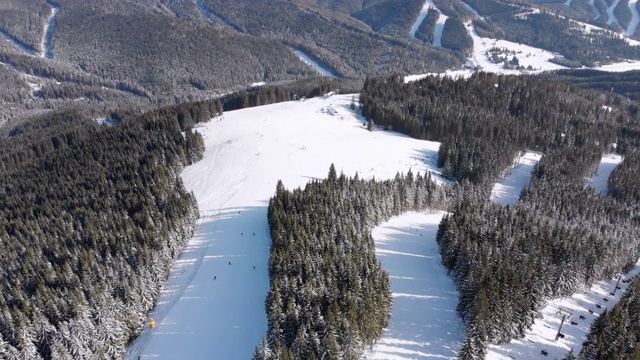 滑雪胜地的空中滑雪场与滑雪者和滑雪缆车。的雪山森林视频素材