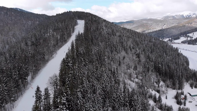 空中滑雪斜坡与滑雪者在滑雪胜地。雪山冷杉林。Bukovel视频素材