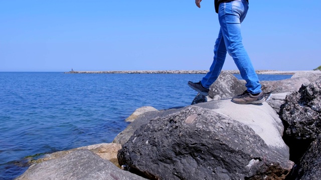 游客来到海边，坐着巨石欣赏海景度假。视频素材