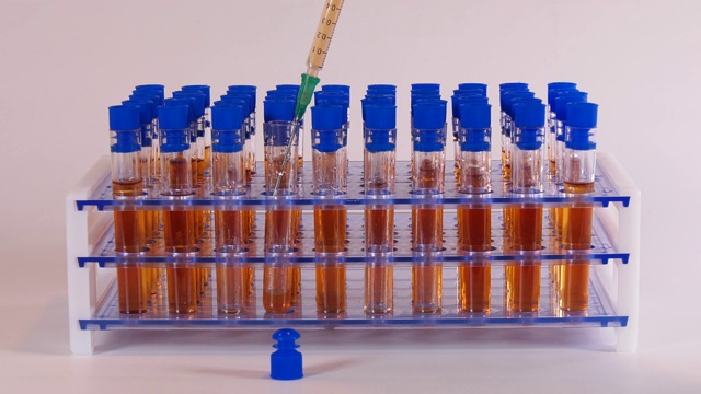 在医学实验室的试管和针与橙色液体视频素材