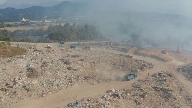 空中拍摄的露天垃圾填埋场焚烧垃圾的4K画面。垃圾填埋场垃圾、塑料、玻璃等，垃圾堆处理场位于沙巴州基纳巴卢视频素材