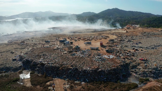 空中拍摄的露天垃圾填埋场焚烧垃圾的4K画面。垃圾填埋场垃圾、塑料、玻璃等，垃圾堆处理场位于沙巴州基纳巴卢视频素材