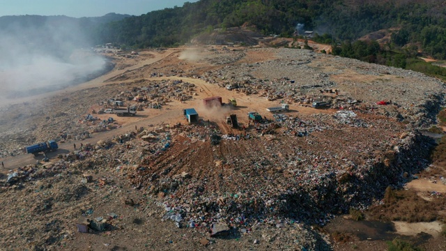 空中拍摄的露天垃圾填埋场焚烧垃圾的4K画面。垃圾填埋场垃圾、塑料、玻璃等，垃圾堆处理场位于沙巴州基纳巴卢视频素材