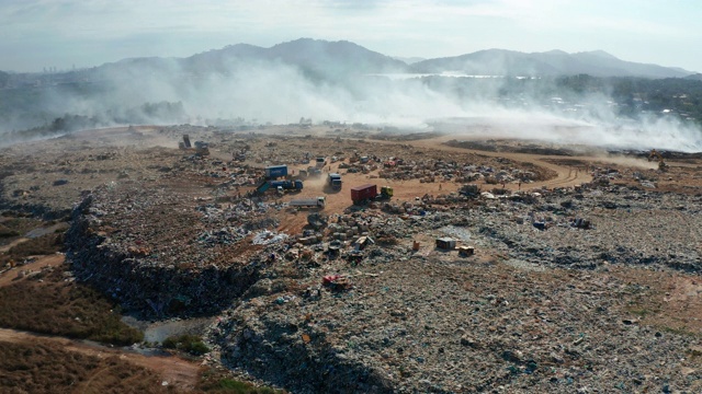 空中拍摄的露天垃圾填埋场焚烧垃圾的4K画面。垃圾填埋场垃圾、塑料、玻璃等，垃圾堆处理场位于沙巴州基纳巴卢视频素材