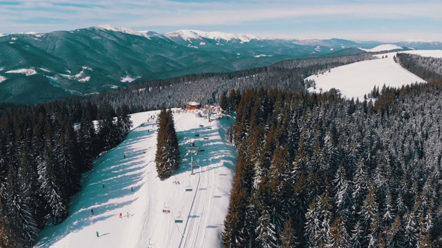 滑雪胜地的空中滑雪场与滑雪者和滑雪缆车。的雪山森林视频素材