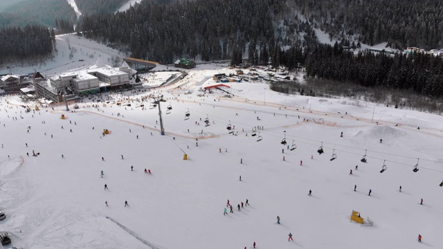 在滑雪胜地滑雪缆车附近滑雪斜坡上滑雪的许多人的鸟瞰图视频素材