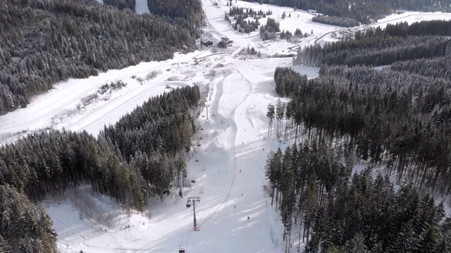 鸟瞰图滑雪者去滑雪胜地滑雪缆车附近的滑雪斜坡。Bukovel视频素材