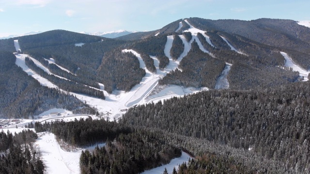 滑雪胜地的空中滑雪场与滑雪者和滑雪缆车。的雪山森林视频素材