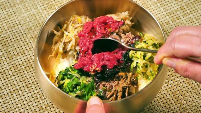 用勺子搅拌“Bibimbap”(韩式混合饭)视频素材