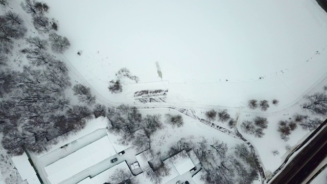 鸟瞰图在一个湖岸边的冬季公园长椅，复古的灯笼和积雪覆盖的人行道上的足迹和脚印视频素材