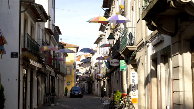 葡萄牙Viana do Castelo，五颜六色的雨伞挂在美丽建筑之间的街道上视频素材