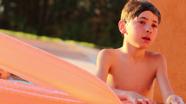 年轻的男孩在游泳池偷拍放松和随意视频素材
