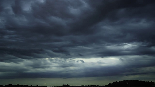 深灰色的风暴云。全球变暖影响黑雷暴戏剧性的雨云戏剧性的天空。光线穿过云层。循环云背景。视频素材