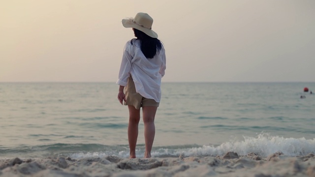 跟踪拍摄。女人走在海滩上美丽的日落。生活方式旅游度假夏季概念。视频素材