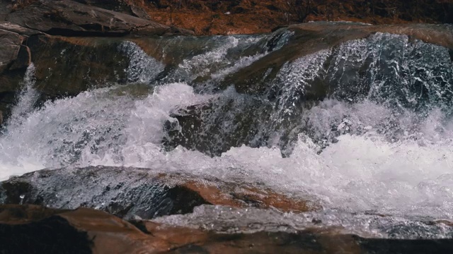 有雪的山溪和石滩。水流湍急。冬天的瀑布。慢动作视频素材