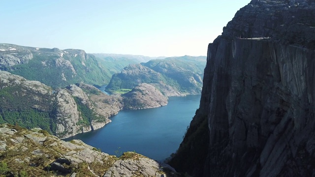 一架无人机在吕瑟峡湾上空飞行，在布道石地区，与讲坛岩石的侧面视图，挪威。徒步旅行的天堂，给你很多自由。美丽的天气。徒步旅行者遗愿清单视频素材