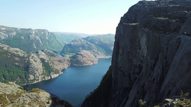 一架无人机在吕瑟峡湾上空飞行，在布道石地区，与讲坛岩石的侧面视图，挪威。徒步旅行的天堂，给你很多自由。美丽的天气。徒步旅行者遗愿清单视频素材