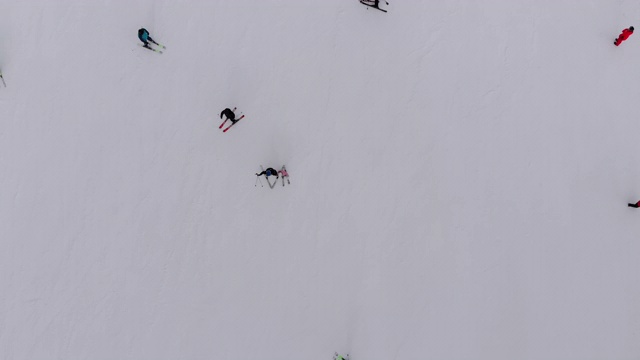 空中俯瞰滑雪者去滑雪胜地的滑雪坡在山上视频素材